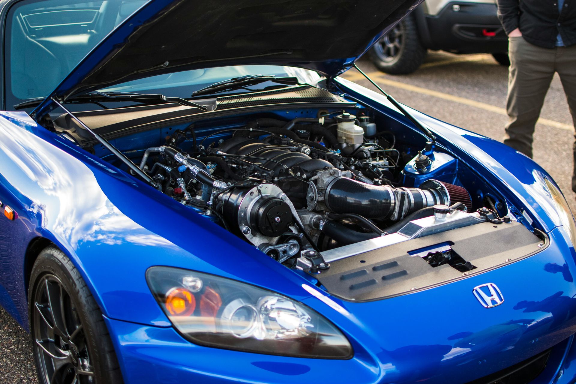 Blue sports car with its hood open, engine exposed